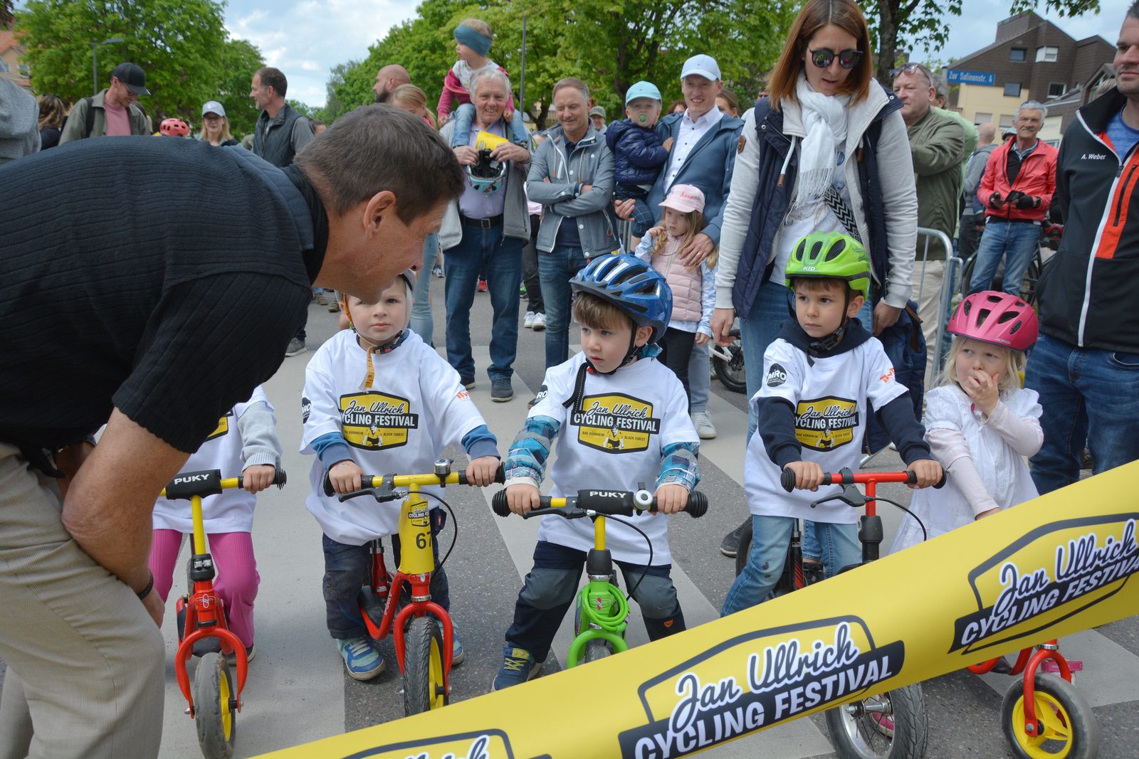 Jan Ullrich mit Kindern am Startband des Laufradrennens